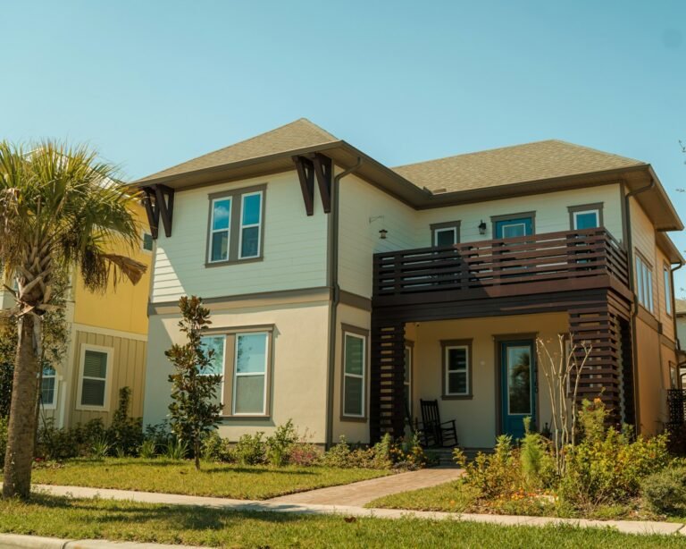 Two-story home with palm trees and a balcony